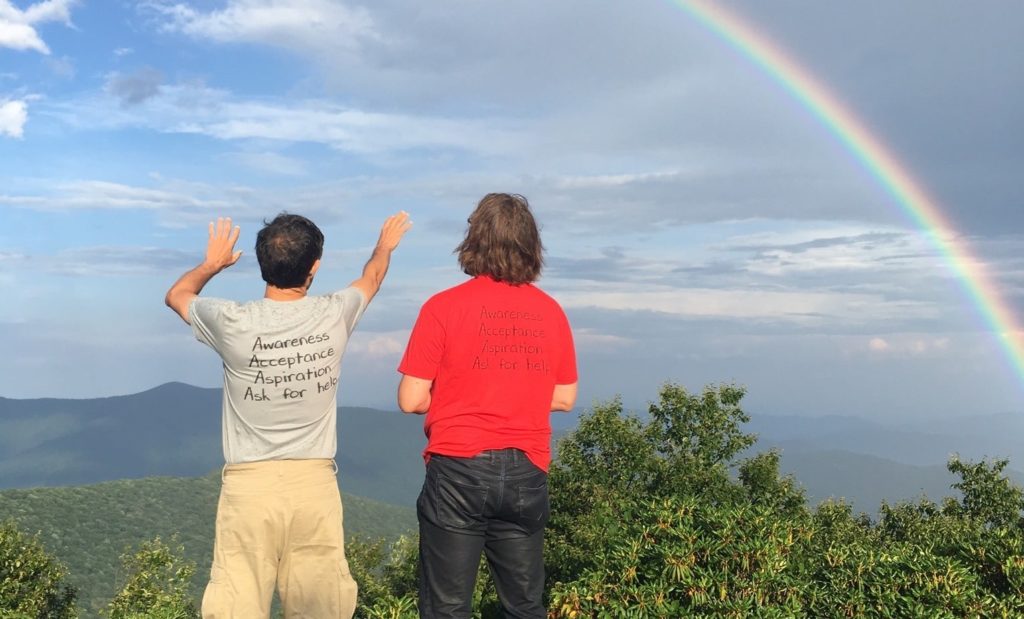Two men looking at the rainbow in nature
