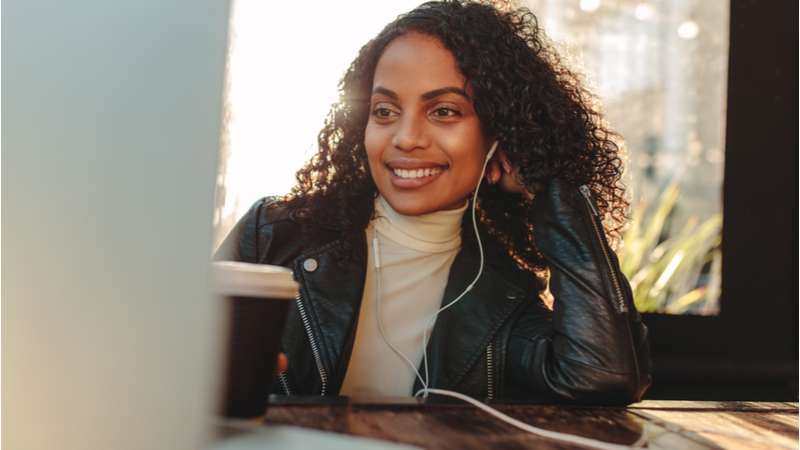 Woman with earphones smiling during a video call