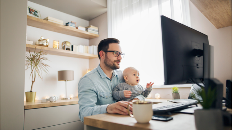Man working from home with his baby in front of the computer