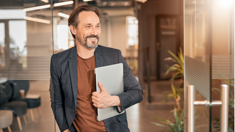 Businessman coming to work with laptop in his hand