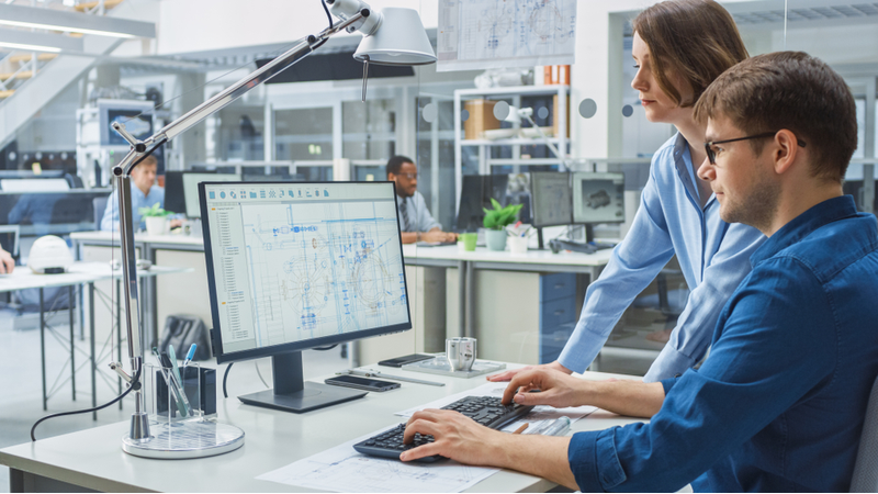 Coworkers analyzing business charts on computer