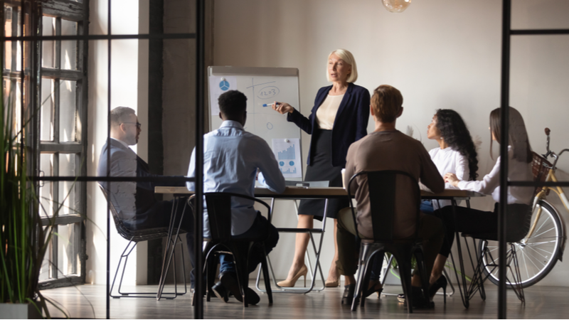 Woman holding a business meeting in front of coworkers