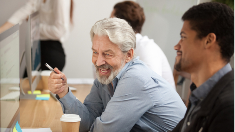 Coworkers looking at computer screen and smiling