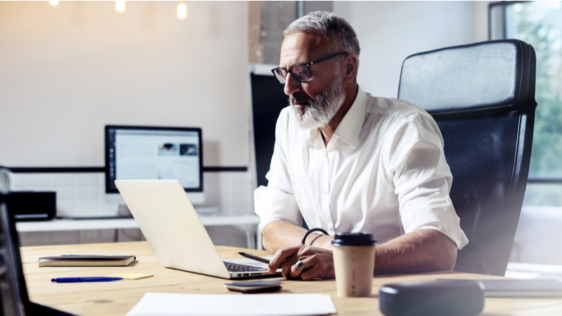 Older man working on laptop in his office