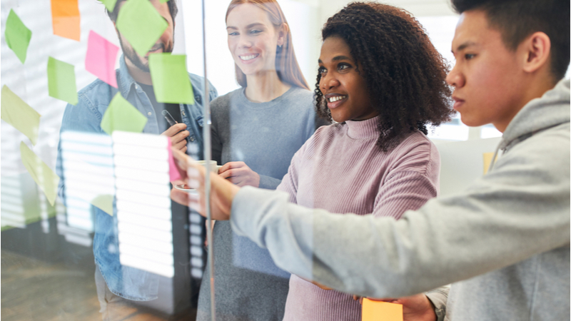 Business team sticking notes on planning board